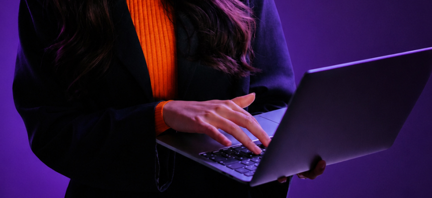 a woman holding a laptop and typing on it